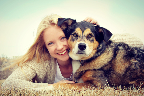 Une femme et son chien allongé dans l'herbe