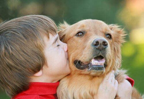 Un enfant qui embrasse un chien.