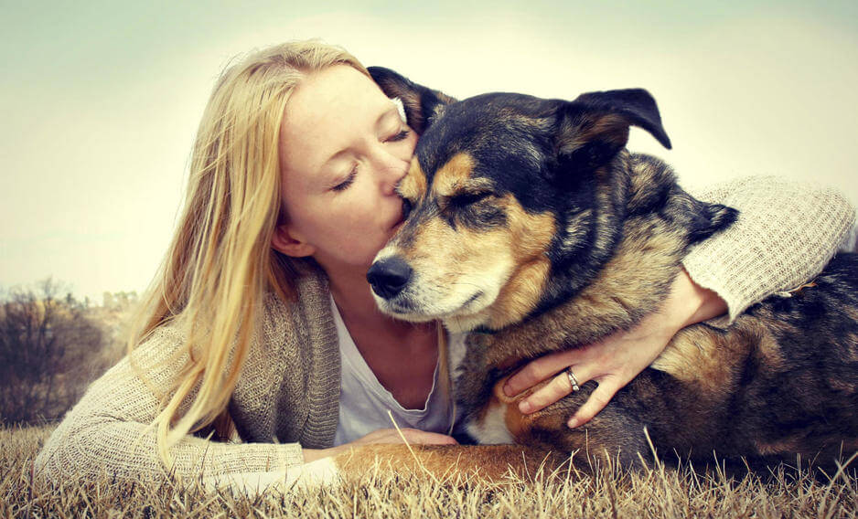 Mujer dándole un beso a su perro