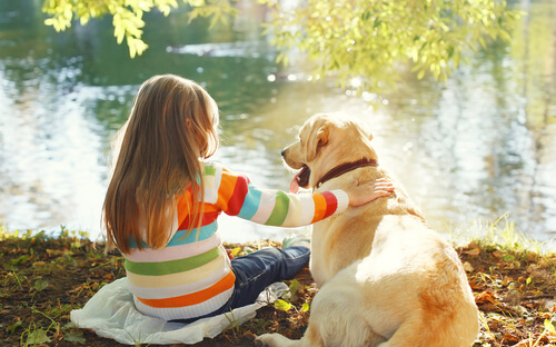 Perro con una niña en el lago