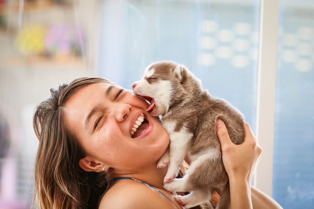 Mujer sonriendo con cachorro.