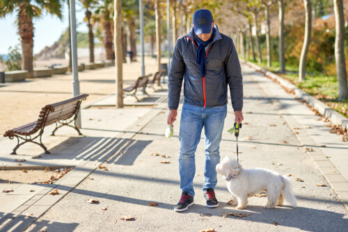 Homme promenant son animal pendant la quarantaine.