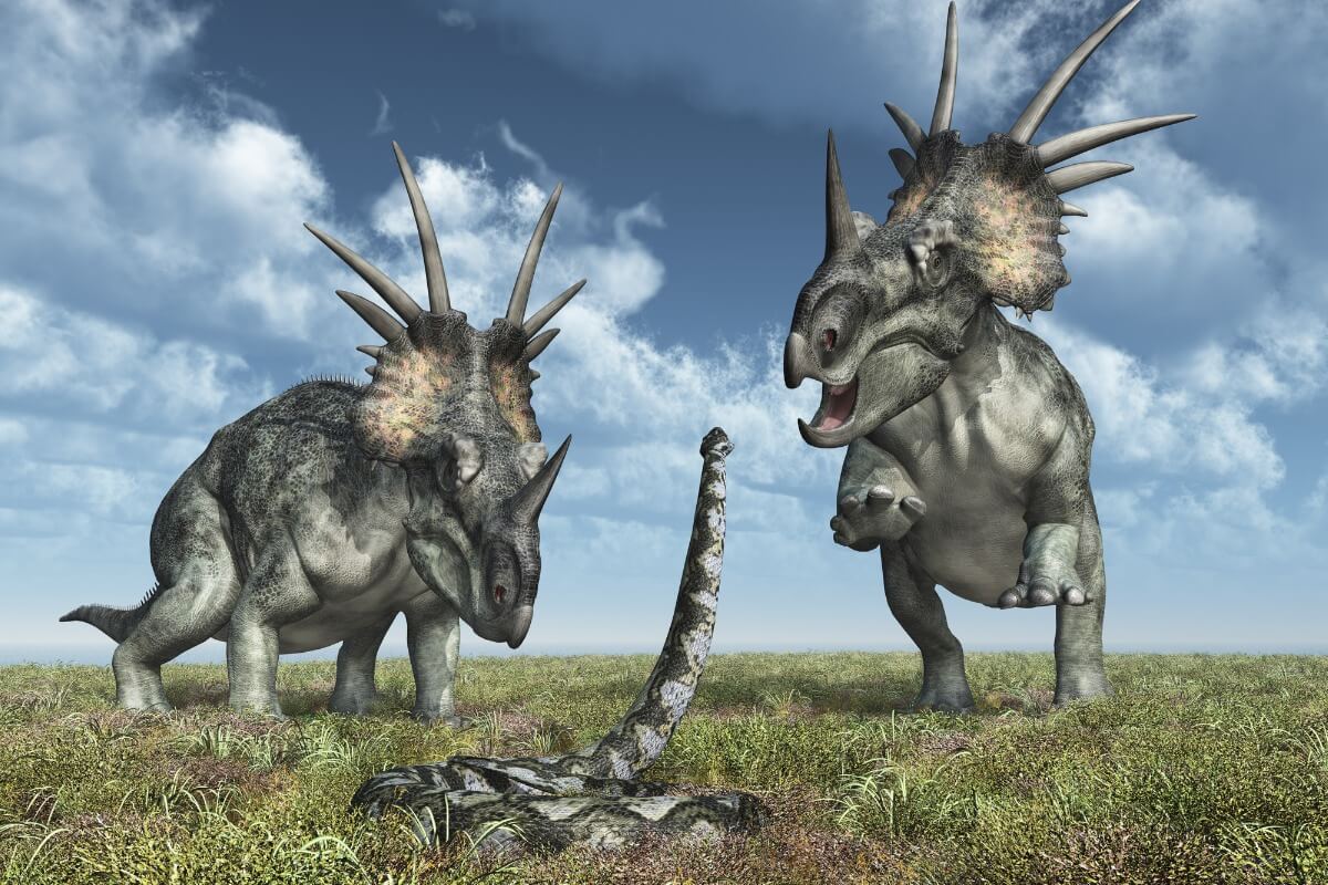 En orm hotar, på ett något orealistiskt sätt, två dinosaurier.