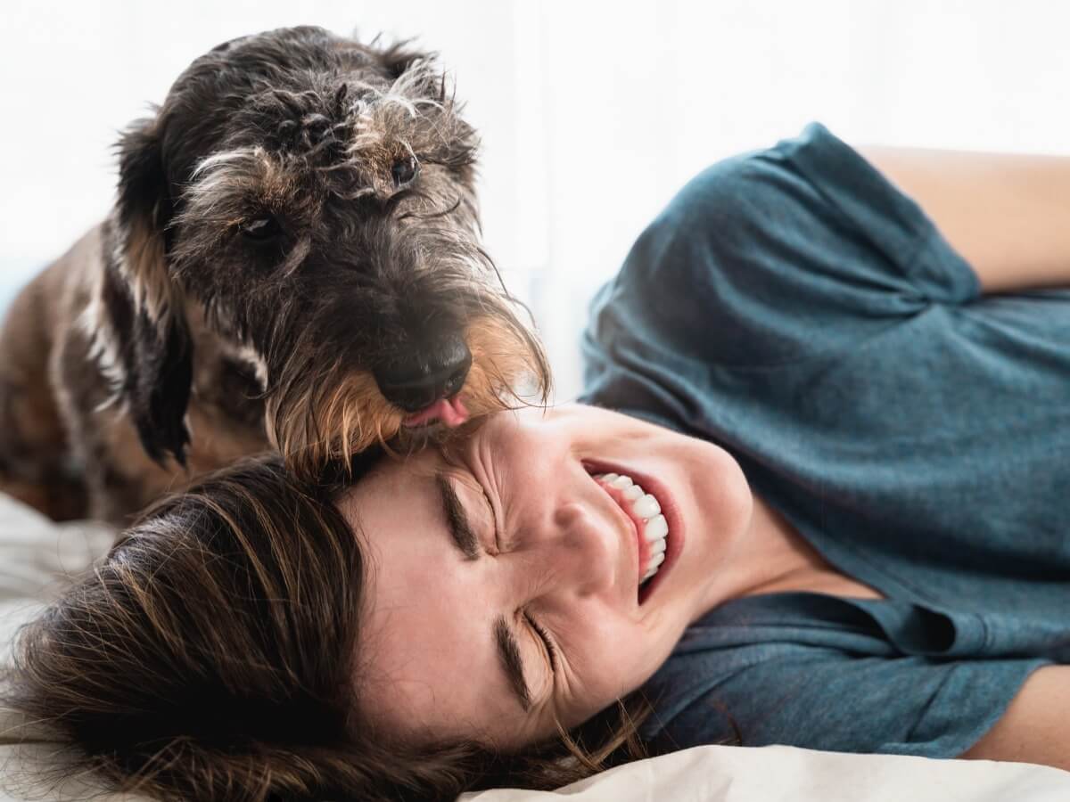 Una mujer juega con su perro.