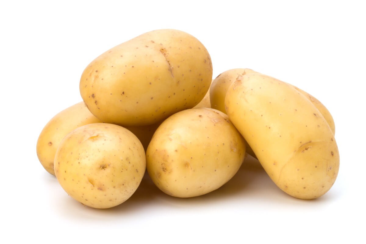 Quelques pommes de terre sur fond blanc.