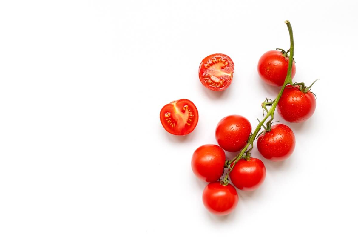 Un tomate sobre un fondo blanco.