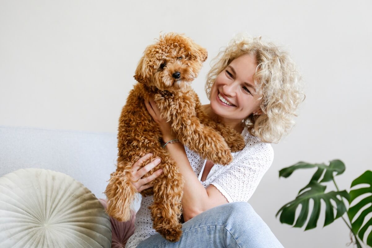 Maltipoo cinsi köpeği olan mutlu bir kadın