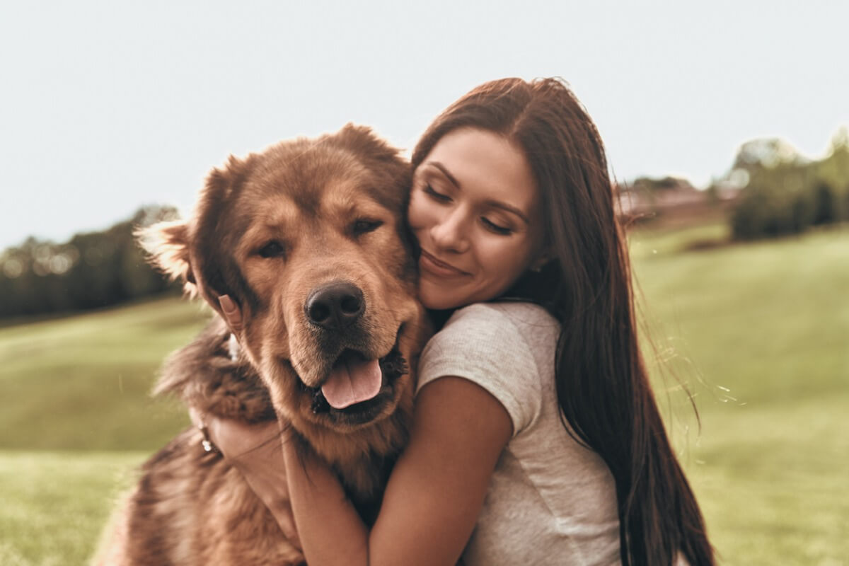 Una mujer le da mucho cariño a su perro.