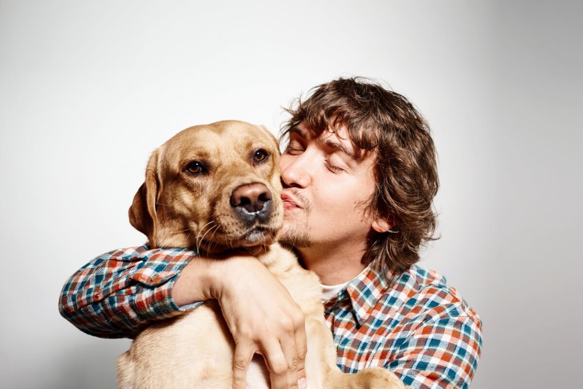 A man hugging a dog.