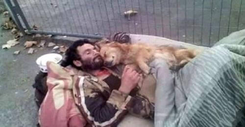 Hombre sin hogar y su perro se abrazan fuerte para consolarse en el desamparo de la calle