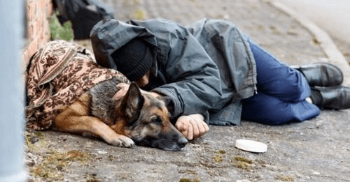 Hombre sin hogar y perrito se aferran abrazados tratando de sobrevivir en el frío