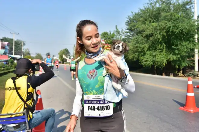 Esta mujer culmina la maratón con el perrito en sus brazos y termina llevándolo a casa.