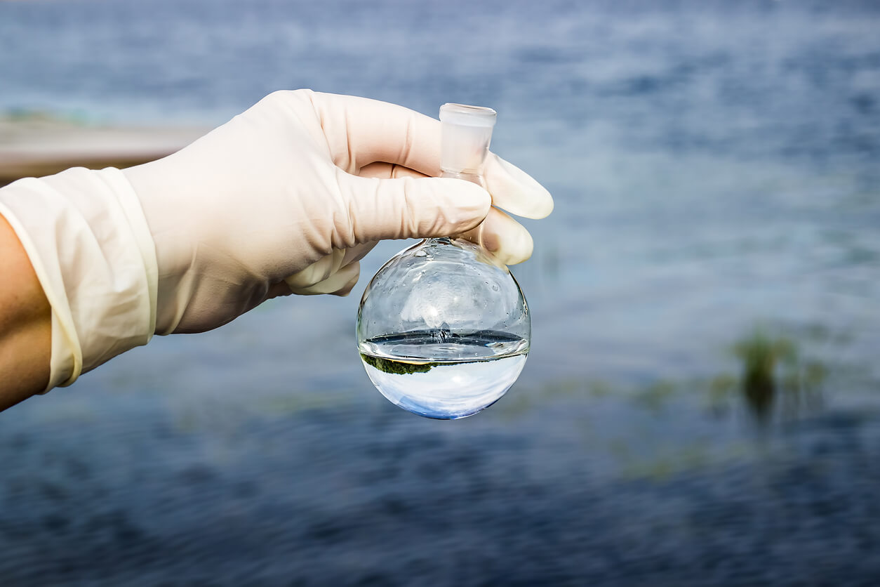 A scientist taking a water sample from a river.